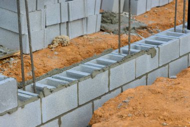 İnşaat işçileri inşaat alanında çalışma günlerinde sağlam temeller oluşturmak için beton bloklar oluşturuyorlar.