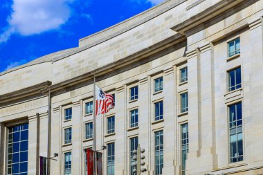 19 Nisan 2025 Washington D.C. ABD Dış İşleri Washington D.C. 'deki Reagan Binası' nın açık mavi gökyüzüne karşı Amerikan bayrağı sergiliyor..