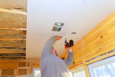 Müteahhit tavana alçıpan yerleştiriyor, ev yenileme projesinde titizlikle çalışıyor..