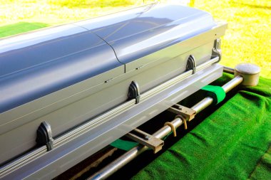 Tabut yeşil yüzeye yerleştirildi. Huzurlu mezarlık atmosferiyle çevriliyken defin için hazırlandı.