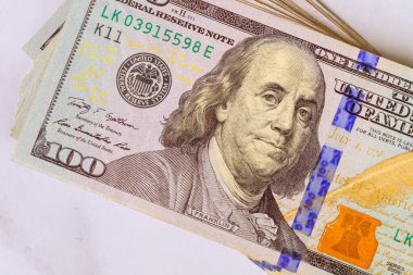 ABD para biriminin benzersiz özelliklerini vurgulayan mermer yüzey üzerindeki 100 dolarlık banknotların çarpıcı düzenlemesi.