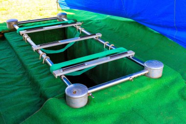 Cenaze töreni sırasında, gümüş tabut tutucu yeni kazılmış mezarın üzerine yerleştirilir, etrafı sessizlikle çevrilir..