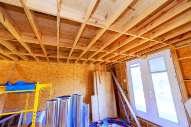 İnşaat odasının tadilatı sırasında ahşap kirişler çeşitli malzemeler sergileniyor.