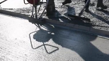 İnşaat işçileri gün içinde temel yüzeyine beton karışımı döküyor.