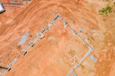 Ekipman inşaat sahasında iken, işçiler yeni binanın temelini atıyorlar.