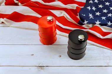 Yakıt varilleri katlanmış Amerikan bayrağında, kırsal arka plana karşı zıt renkler sergiliyor..