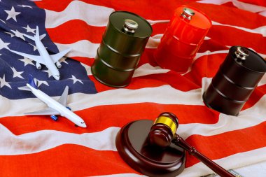 Amerikan bayrağı üzerinde yargı tokmağı ile düzenlenmiş uçak petrol varillerinin modelleri ticareti ve yasaları sembolize ediyor.