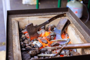 Demirciler geleneksel metal çalışma tekniklerini balta yapımında ısıtmalı araçlar kullanarak kullanırlar..