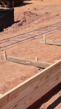 İşçiler temelleri ahşap formlarla, demirle, yaklaşan inşaatlar için istikrar sağlayarak hazırlıyorlar..