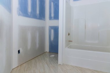 Yenileme sırasında banyoya yeni kurulmuş bir küvet ve bitmemiş alçıpan döşemeleri..