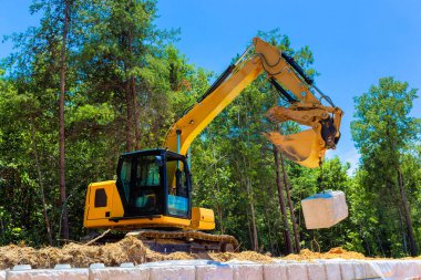 Ağır makineler, istinat duvarları inşa projesi sırasında büyük taş blokları aktif olarak kaldırıyor