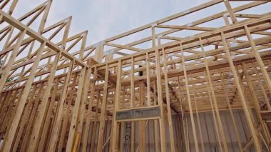 İşçiler ahşap çerçeve yapısı inşa ediyorlar, inşaat alanında kirişlerin karmaşık düzenlenmesi