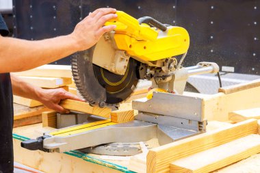 Marangoz ustalıkla iş günlerinde tahta testeresi kullanır.