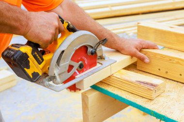 Marangoz keresteyi dairesel testere ile keser, atölyedeki detaylara dikkat eder..