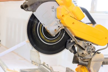 Daire testere, iyi aydınlatılmış inşaat alanında ahşap kesiyor. Bu da ustalığın gelişmekte olduğunu gösteriyor..