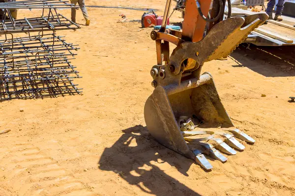 İnşaat çalışmaları sırasında inşaat alanında toprak taşımacılığıyla aktif olarak uğraşan ağır makineler, işçilerin yanı başında.