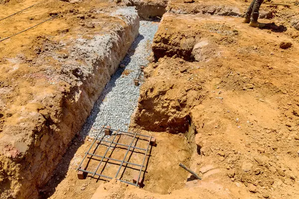 İnşaat sürecinde temel istikrar için çukur döşeyen çakıl dolu bir çukur kazmak gerekiyor..