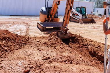 Müteahhit inşaat alanında kazıcıyı ustalıkla çalıştırıyor siper kazıyor