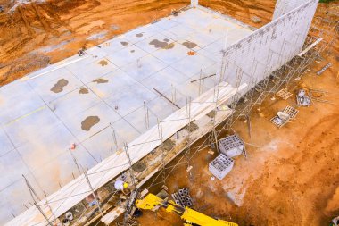 İşçiler inşaat inşaatı için inşaat iskelesi makineleri kullanıyorlar..