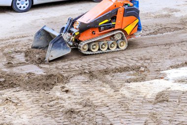 Küçük inşaat aracı inşaat alanındaki kiri temizliyor.