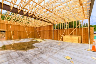 İşçiler yeni bir yapı oluştururken, sağanak yağış beton yüzeyde su birikintileri oluşturuyor.