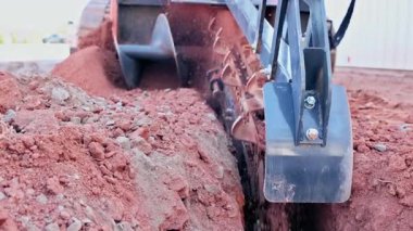 Ağır siper makineleri kuru zemini kazarak inşaat alanında siper oluşturuyor.