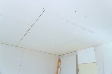 Yeni alçıpan paneller tavan ve duvarları kaplıyor, yerleşim alanındaki yenileme çalışmaları devam ediyor.