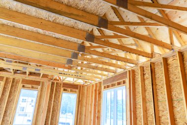 Tamamlanmamış bir konut binasında pencereleri açık olan ahşap iskelet inşa ediliyor.