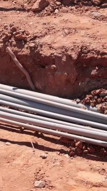 İşçiler inşaat sahasına elektrik tesisatı kuruyor, kamu hizmetleri için zemin hazırlıyorlar.