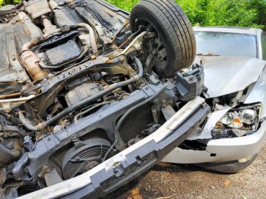 Takla atan araba, çarpmanın ardından ağaçlık alanda başka bir araca yaslanıyor..