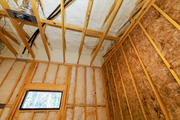 İç oda, modern evdeki açıkta duran ahşap çerçeve ve yalıtım inşaatı çalışmalarını gösteriyor..