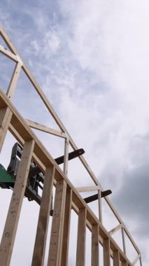 Ağır telgraf makineleri inşaat alanında yeni yapı inşaatı için tahta kirişleri kaldırıyor.