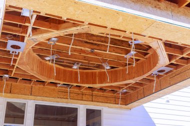 Zanaatkarlar, çalışma gününde ev ekinde dairesel ahşap tavan özelliğini birleştiriyorlar.