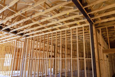 Yeni konut inşaatının içinde devam eden inşaat çalışmaları sırasında ahşap çerçeve destek kirişleri sergileniyor.