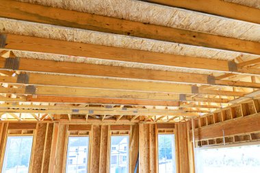 Açığa çıkan ahşap çerçeve, geniş pencereli konut inşaatında büyük güneş ışığına izin veren ilerlemeyi ortaya koyuyor.