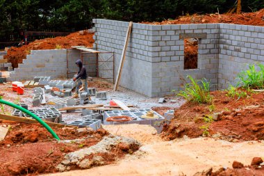 İnşaat işçisi iş günü inşaat alanında beton bloklar birleştiriyor