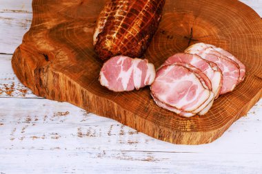 Dilimlenmiş domuz filetosu, ahşap kesim tahtasının üzerinde, sade görünümlü, rahat mutfak titreşimli..