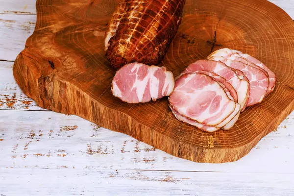 Dilimlenmiş domuz filetosu, ahşap kesim tahtasının üzerinde, sade görünümlü, rahat mutfak titreşimli..