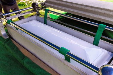 Yas tutanlar, kasvetli vedalaşmalarında sevdiklerini onurlandırmak için, cenaze mezarlığındaki tabutun etrafında toplanırlar..