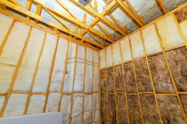 Çalışanlar çalışma saatleri boyunca ses yalıtımı malzemeleriyle yeni ev yapımı odaları yalıtıyorlar..