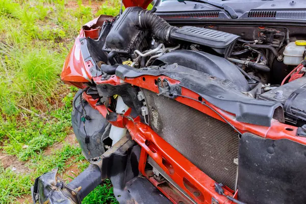 Kırmızı arabanın ön yüzünde ciddi hasar var. Motor parçaları sigorta tazminatına hazır.