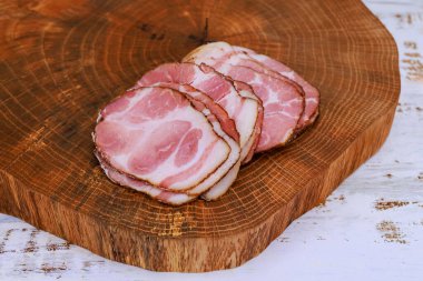 Sıcak mutfak atmosferinde, doğal ahşap tahtada düzgünce hazırlanmış et dilimleri..