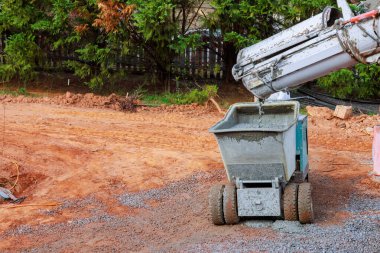Beton karıştırıcı inşaat alanındaki çöp kamyonuna yeni çimento döküyor.