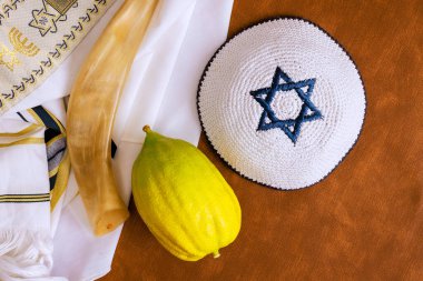 Traditional Jewish holiday etrog fruit with religious books. Sukkot celebration symbols