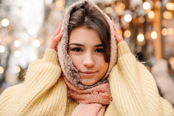 暖かいセーターとウールのスカーフを着て 外にポーズを取って祝う笑顔の女性 冬の市場の休日フェア 旅行精神リゾート 新年のクリスマスの装飾 ガーランド — ストック写真