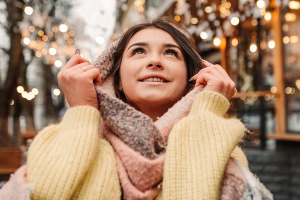 暖かいセーターとウールのスカーフを着て 外にポーズを取って祝う笑顔の女性 冬の市場の休日フェア 旅行精神リゾート 新年のクリスマスの装飾 ガーランド — ストック写真