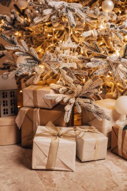 Konforlu dairenin dikey görüntüsü yeşil Noel Ağacı hediyeleri çelenkler, mumlar dekore edilmiş oyuncaklar yeni yıl baloları akşamları güzel oturma odaları ışıldayan ışıklar bokeh