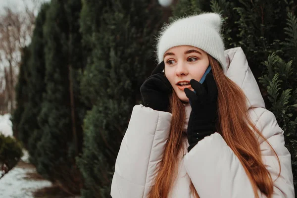 ショックを受けた女性の暖かいジャケットを着て クリスマスツリーの近くに立って 携帯電話のジェスチャーを話す 冬の休日 旅行精神リゾート 新年のクリスマス飾り — ストック写真
