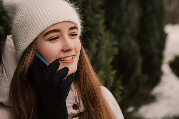 若いかわいい女性は クリスマスツリーの近くに立って 携帯電話のジェスチャーを話して 暖かいジャケットを着て祝う 冬の休日 旅行精神リゾート 新年のクリスマス飾り — ストック写真