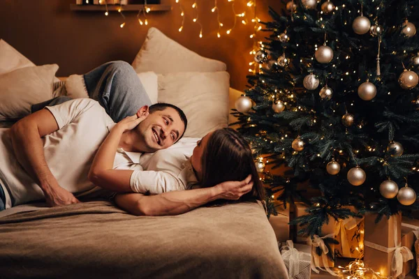 연인들 침대에 분위기에 입맞춤하며 크리스마스 컨셉트 파티를 즐기고 있습니다 — 스톡 사진